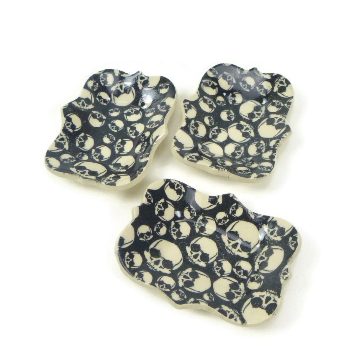 Large scalloped trivet with black and white skull patterning