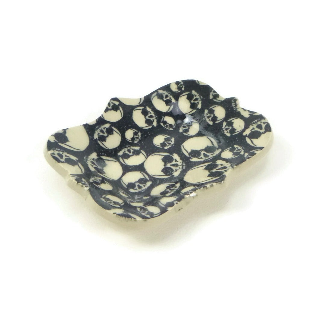 Large scalloped trivet with black and white skull patterning