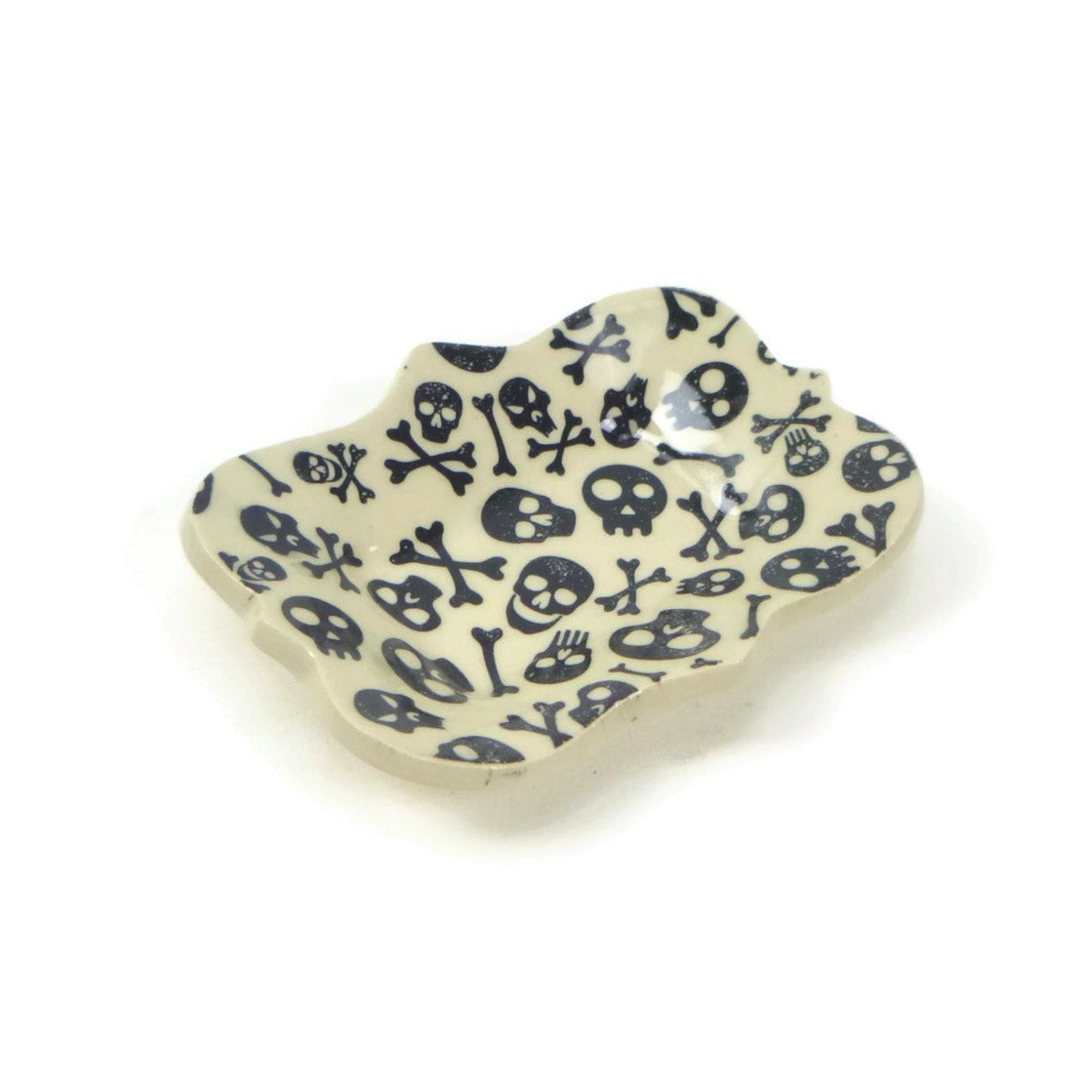 Large scalloped trivet with skull and crossbones patterning